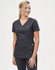 A solid black short-sleeve scrub top worn by a smiling woman, featuring a v-neck and pockets.