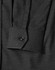 A close-up of a black pin dot stretch long sleeve shirt with a buttoned cuff and subtle pattern details.