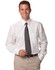 A man wearing a white dress shirt and a grey tie, standing with a friendly smile and beige trousers.