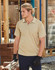 A khaki short-sleeve polo shirt with a logo, featuring textured shoulder panels and worn with black gloves.