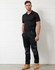 A black short-sleeve polo shirt features a logo, paired with dark trousers and tan work boots.