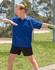 A girl wearing a blue polo shirt and black shorts, posing outdoors near a fence. The shirt features a logo.