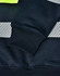 A close-up of a navy work jumper featuring reflective stripes and a high-visibility yellow neckline, with ribbed cuffs.