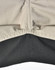 A close-up of Rip-Stop poly/cotton stretch work pants, featuring a beige upper section and a black lower section with stitching.