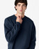 A navy Gildan Softstyle adult sweatshirt featuring a crew neck and long sleeves, with a logo on the sleeve.