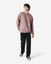 A male model wears a dusty pink Gildan Softstyle Adult Sweatshirt with black pants and black sneakers. The sweatshirt has a simple design.