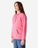 A pink Gildan Softstyle adult hooded sweatshirt displayed on a model. The sweatshirt features a front pocket and a hood.
