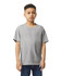 A grey Gildan Youth Softstyle short sleeve T-shirt displayed on a model standing with hands at sides.