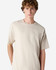 A light beige super heavyweight T-shirt on a model, featuring a relaxed fit and short sleeves. It has a logo.