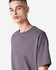 A model wears a purple American Apparel Super Heavyweight T-Shirt, featuring a simple design and relaxed fit.