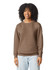 A brown crewneck sweatshirt featuring a relaxed fit. The model has curly hair and is smiling. The sweatshirt has a logo.