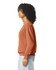 A lightweight crewneck sweatshirt in a warm rust colour, featuring a side view of a model with curly hair.