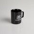 A black coffee mug with a glossy finish and a handle, featuring a logo.