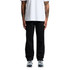 Black relaxed pants worn by a person standing, paired with a plain white t-shirt and athletic shoes.