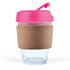 A reusable coffee cup with a transparent body, pink lid, and a cork band around the middle.
