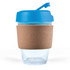 A reusable coffee cup with a clear body, a blue lid, and a cork band for insulation.