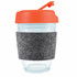 A reusable coffee cup with a transparent body, an orange flip lid, and a grey RPET band for grip.