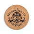 A round cork coaster featuring a black design with bold text and a logo, showcasing a rustic, natural look.