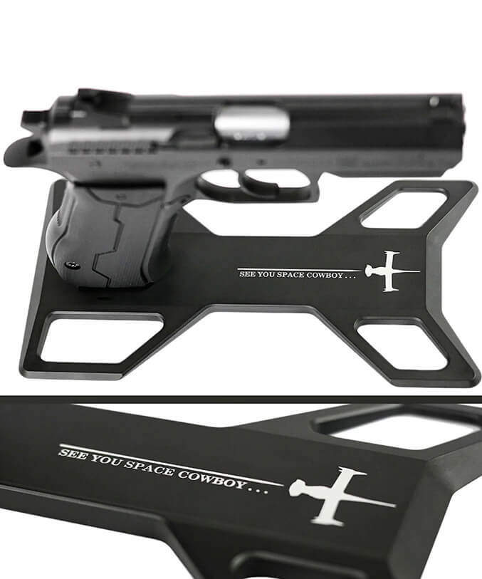 Handgun standing on a black gun stand with white text on the base.
