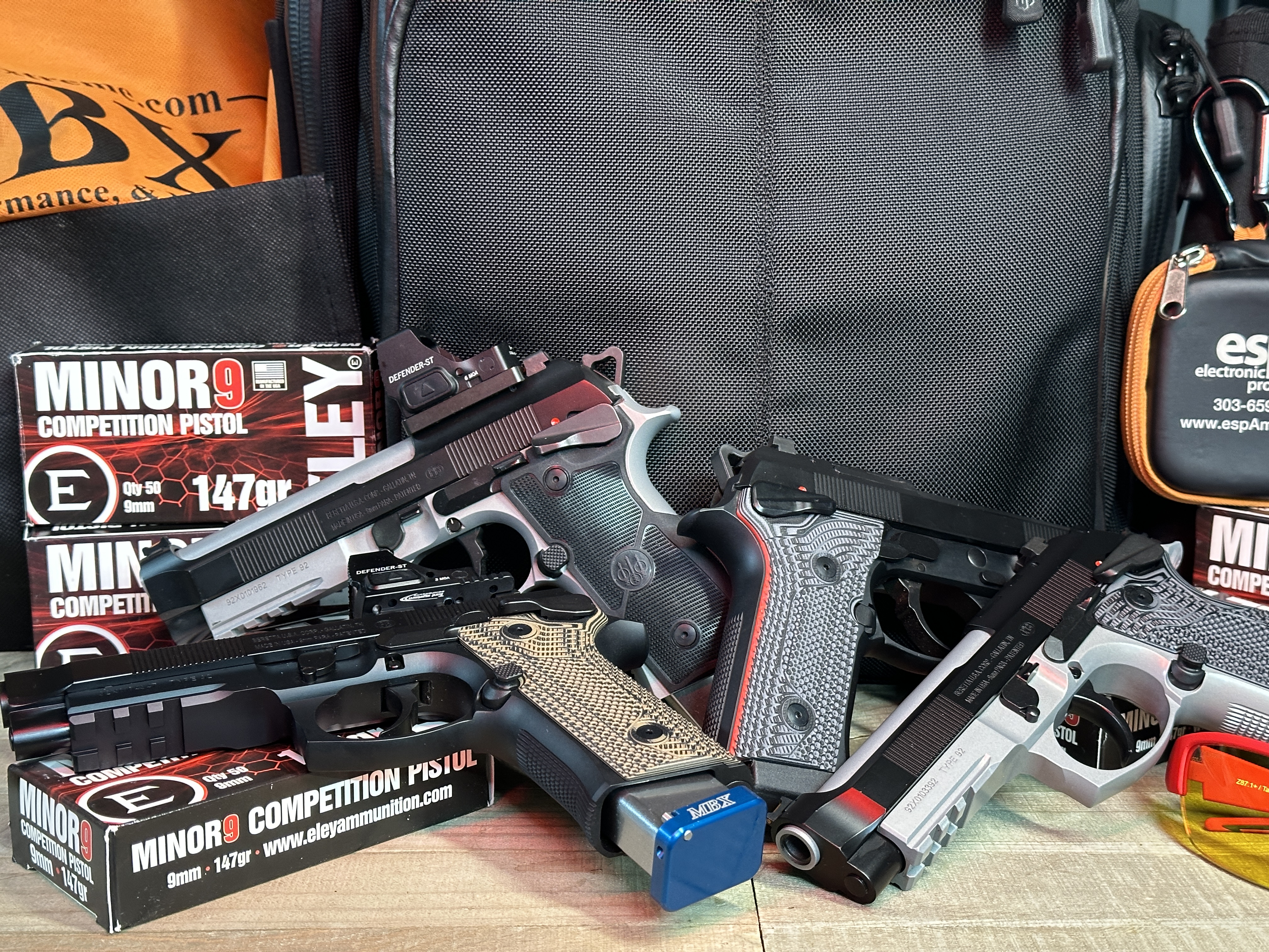 Various competition pistols on display with ammunition boxes.