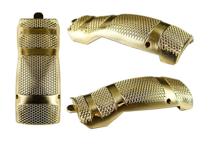 Stainless steel 1911-style semi-automatic handgun with black grips resting on a tree stump alongside a chain and spent shell casings.