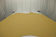 Picture of Goldenrod Pebble, honey gold colored leather hide for upholstery displayed on a table