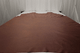 Picture of Whiskey Beat, rich warm brown semi-aniline leather hide for upholstery displayed on a table