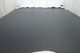 Picture of a dark steel blue leather hide for upholstery lying flat on a table