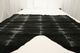 Picture of black and white tie-dyed effect suede displayed on a table 