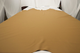 Picture of golden barley pigmented upholstery leather hide displayed on a table