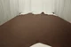 Picture of dark brown with red/brown undertones natural mill pebble leather for upholstery displayed on a table