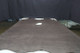 Picture of Thunderstorm Distress, grey semi-aniline leather hide for upholstery displayed on a table.