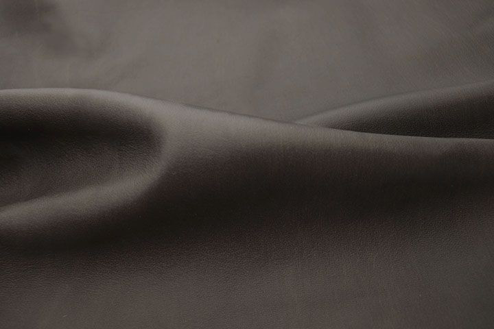 Close up picture of Lambskin Anthracite, a soft dark grey leather with natural grain texture.