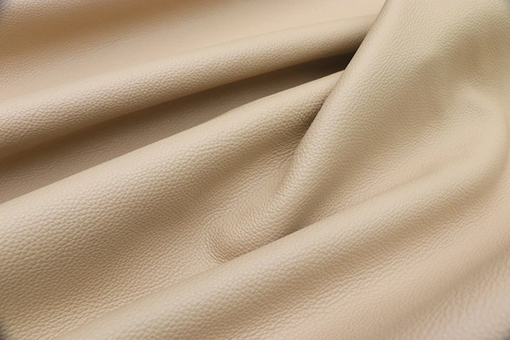 Close-up picture of Bisque, warm tan full grain leather for upholstery with pebble grain texture