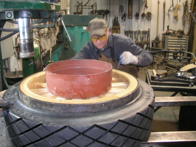 Repairs applied to large wheel inside workshop