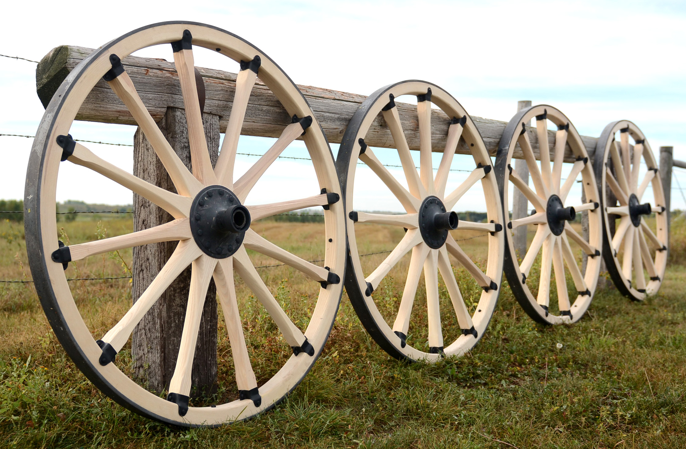 Display of rebuilt cannon wheels along fence