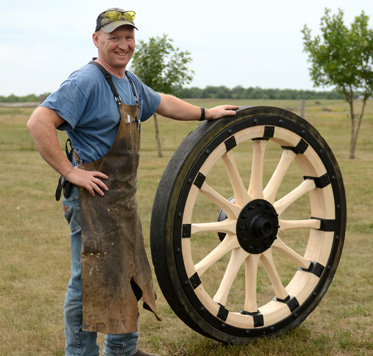 Wheelwright Tim Hoffman with rebuilt heavy wheel for cannon