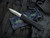 PRE-OWNED Heretic Knives Manticore X Recurve Blue Camo Carbon Clipside/Black Aluminum Body w/ Battleworn Plain Edge Blade (3.7")