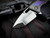 Heretic Knives Custom Medusa Manual Folder Entropic Anodized Titanium Inlaid Carbon Fiber Body w/ Elmax Hand Ground DLC Tanto Plain Edge Blade (3")