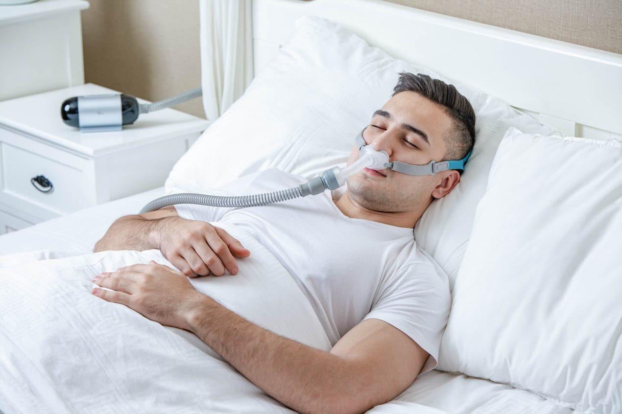 BMC P2H Nasal Pillows Starter Kit, man sleeping with nasal pillow mask for sleep apnea therapy.