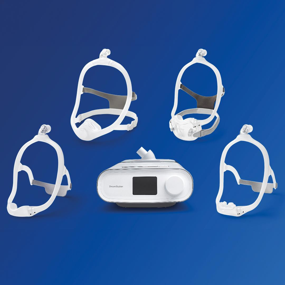 Philips Respironics DreamStation Pro CPAP with Philips Mask, humidifier version, and headgear accessories on a blue background.