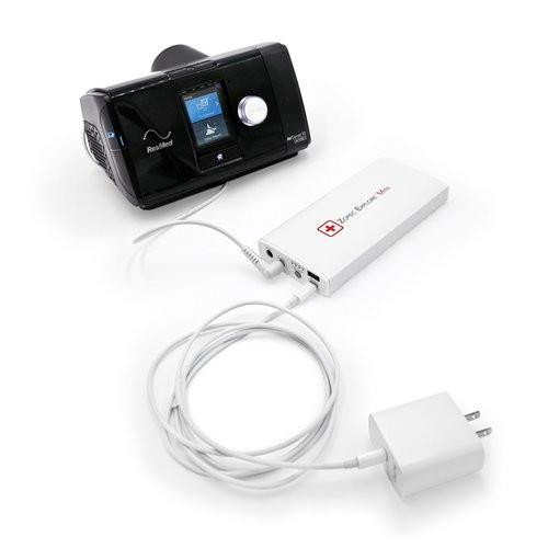Zopec Explore Mini, portable CPAP machine with a control screen, connected to a power bank and charger for travel use.