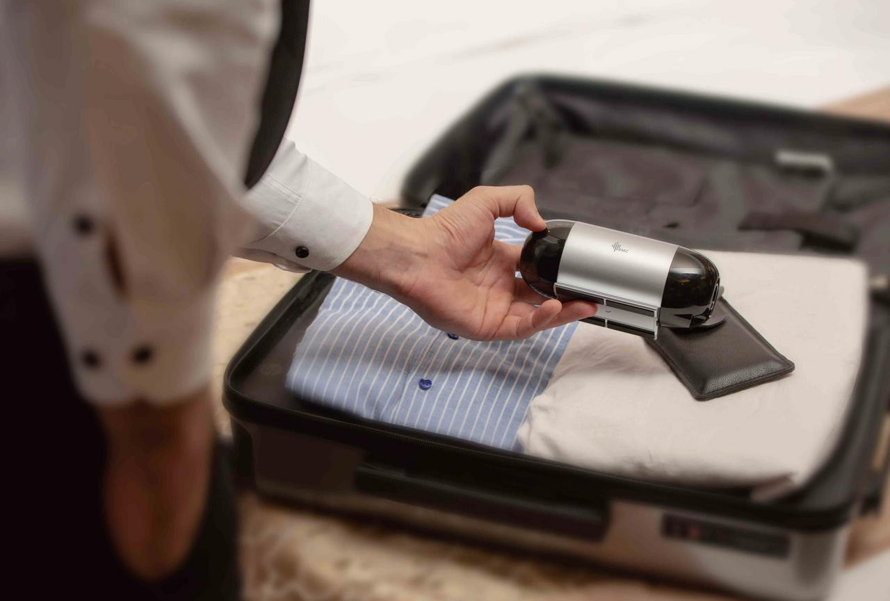 BMC M1 Travel Auto CPAP Mask Package, a person packing the portable CPAP machine into a suitcase for travel.