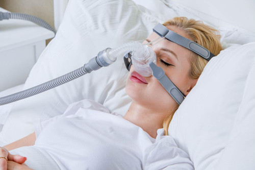 BMC N5H Nasal Mask, woman using nasal mask for sleep therapy while resting in bed.