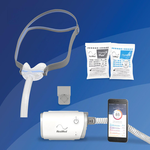 Resmed N30 Airmini Starter Kit, includes a compact air pressure device with a flexible hose connected to a mask, two sachets of HumidX Plus and HumidX moisture exchange devices, an adjustable head strap, and a smartphone displaying sleep data.