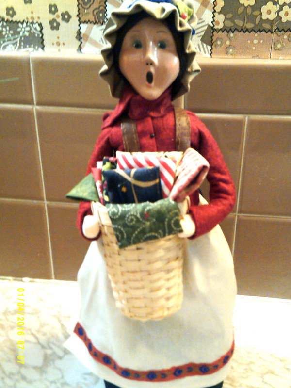 2024-BYERS CHOICE CAROLER-WOMAN SELLING FABRIC-NEW