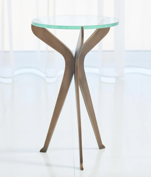 A small scale drinks table formed from three flat "slices" of solid brass welded together at a central point. The "slices" are designed to give the table adequate support with the floor and also create the three point resting place for a thick sheet of tempered glass. Small neoprene dots keep the glass in place and from moving along with three points on the top of the "slices". 
