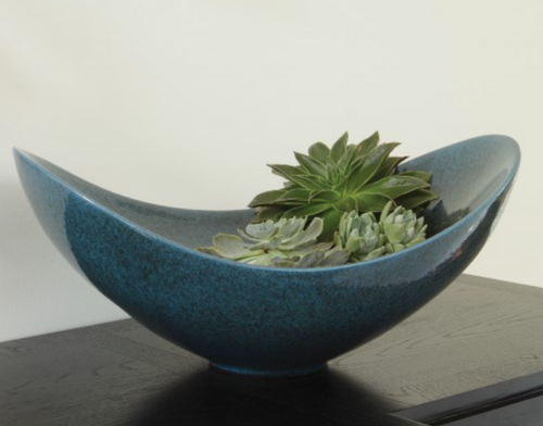 
These dramatic silhouettes are extremely difficult to achieve on this scale, but the results are stunning. The height, proportion, and negative space of the ring vases lend to the overall impact of these unique pieces. The celestial color, a rich dark teal / greenish navy tone, is achieved with a multi dimensional reactive glaze.