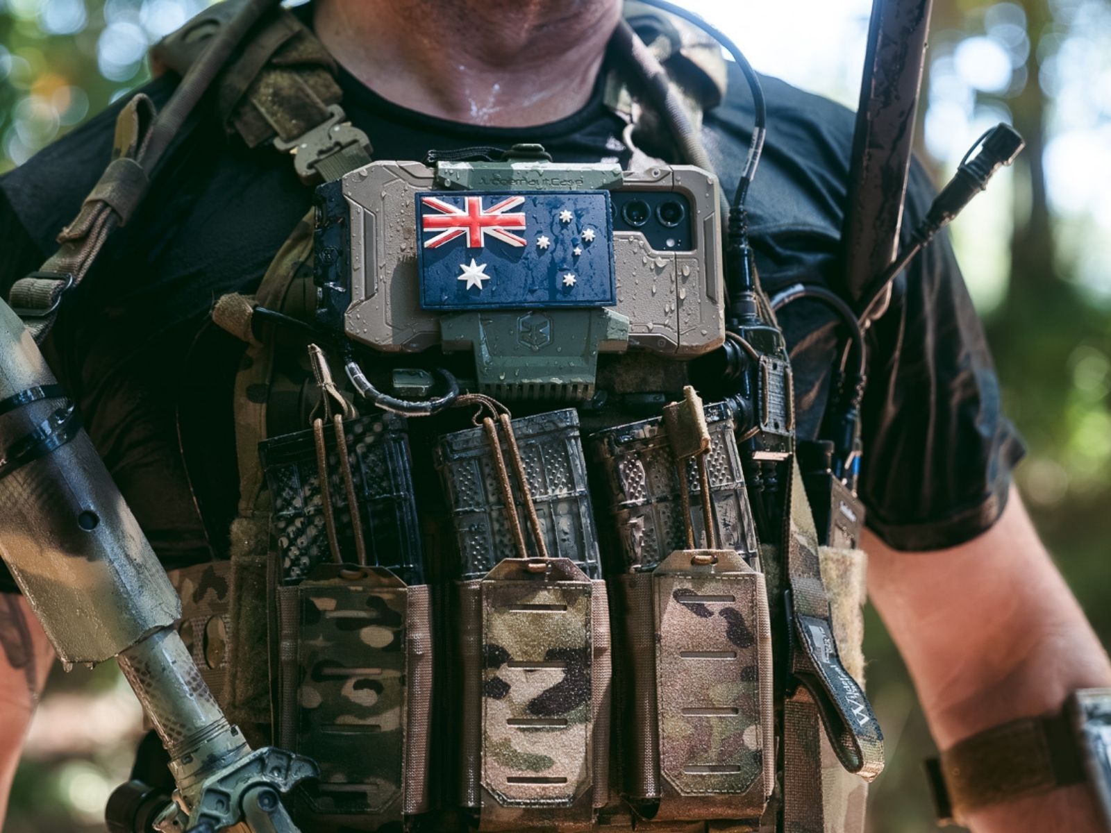 Operator with a phone secured to a plate carrier using a Juggernaut Case armor mount