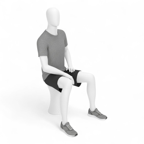 Seated white male mannequin wearing a grey T-shirt, black shorts and grey trainers